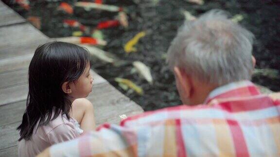 亚洲爷爷和孙女在公园里聊天