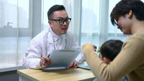 医生正在检查小男孩并与母亲交谈