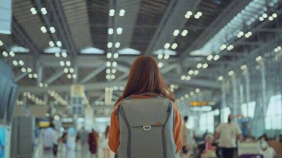 女子背着背包走在机场候机楼旅游旅行