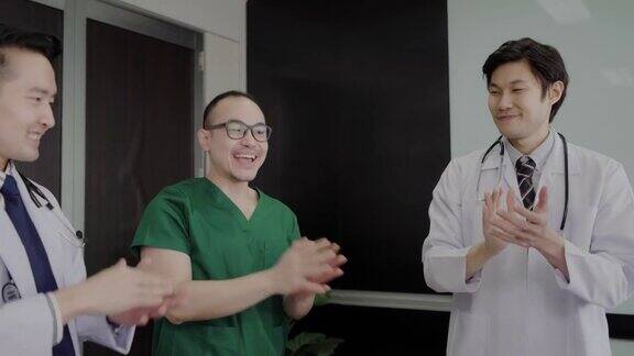 一群亚洲医生双手合十举起头顶