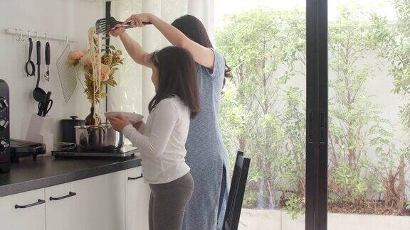 亚洲日本妈妈和女儿在家里做饭生活方式女性在家里的厨房里一起做意大利面和意大利面当早餐慢动作镜头