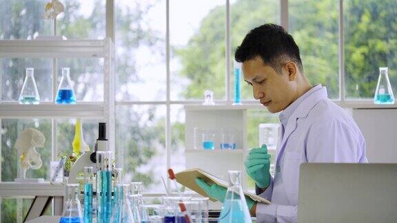 在科学实验室从事研究工作的亚洲男性科学家显微镜用于检测病毒用于治疗covid-19新毒株等疾病的疫苗生产处理技术