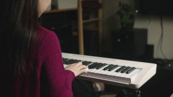 年轻女子在网上用在家视频教程上钢琴课