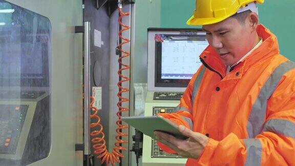 工业工程师戴安全帽穿安全服使用触屏平板电脑他在重工业制造厂工作ภาพ
