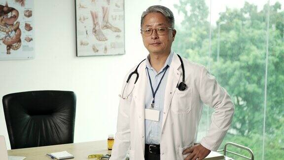 成熟的中国医生的肖像在医生的办公室