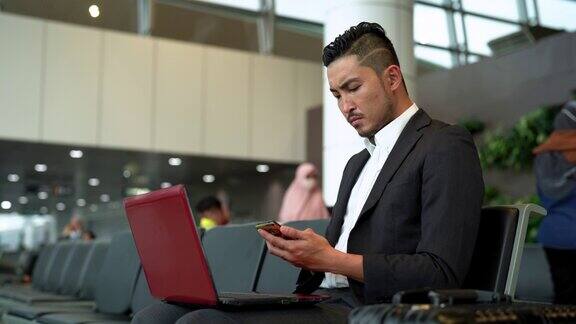 亚洲商人在机场使用笔记本电脑