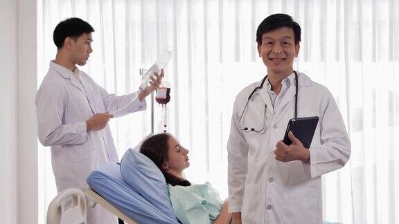 亚洲医生男性经验丰富的医疗从业者自信的微笑而看着相机摆姿势独自在医疗诊所医生在看视频会议工作的骄傲男医务人员