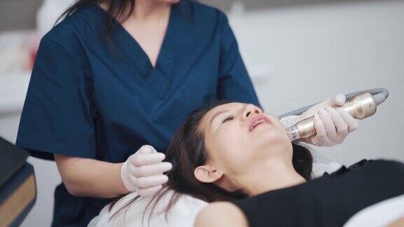 亚裔华人女美容师正在给她的病人进行微晶磨皮治疗