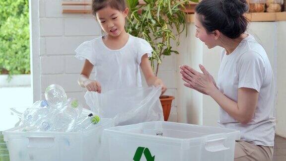 快乐的亚洲母亲教小女儿可持续发展如何在家里回收家庭垃圾教学习可重复使用的产品和零废物家庭教育日常循环利用