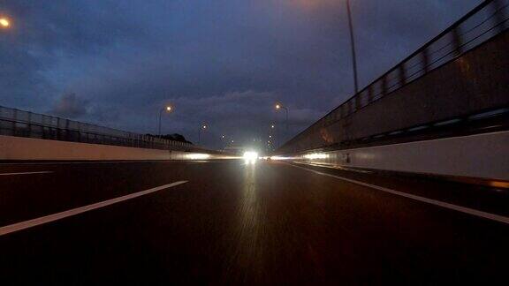 黄昏时在高速公路上行驶后视图