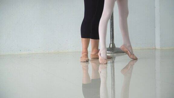 从低角度观看:教师正在教芭蕾舞学生的脚