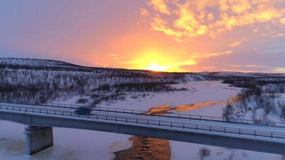 图片:日落时分一辆汽车正从结冰的河面上过桥