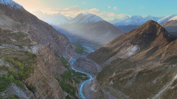 巴基斯坦北部吉尔吉特-巴尔蒂斯坦罕萨山谷的河流和喀喇昆仑山脉的空中无人机日出景观