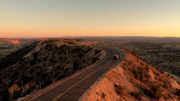 图片:黑色SUV在夕阳下沿着山脊公路行驶