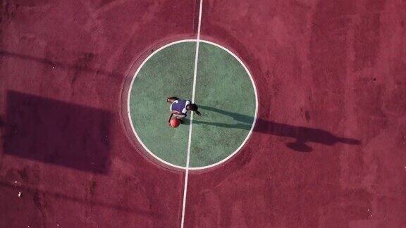 一个年轻人正在一个临时篮球场打篮球