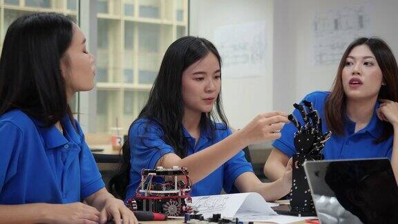 亚洲工程师团队在实验室组装和测试机器人反应建筑师设计电路和工程师会议分享技术想法和协作开发机器人
