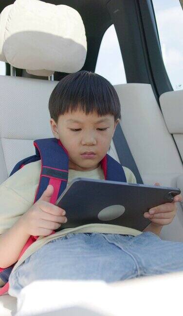 小男孩在车内使用数码平板电脑