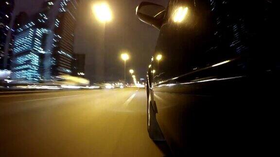 快速城市驾驶夜间道路POV通过城市在夜间时间推移左侧的汽车低角度的观点