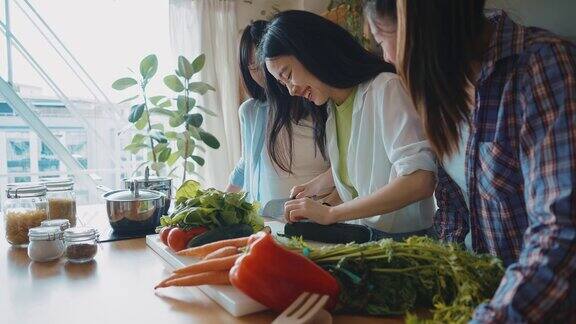 三个快乐的年轻女子在厨房准备亚洲食物