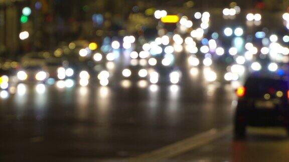 夜城开车灯交通堵塞警车的应急灯在夜间失去焦点雨后潮湿的路面上反射的汽车前灯模糊不清