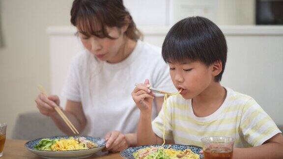 父母和孩子吃着冰镇的中国面条