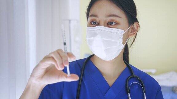 近距离的女性亚洲医生持有疫苗注射针准备接种疫苗年轻的医学实验室技术员在工作