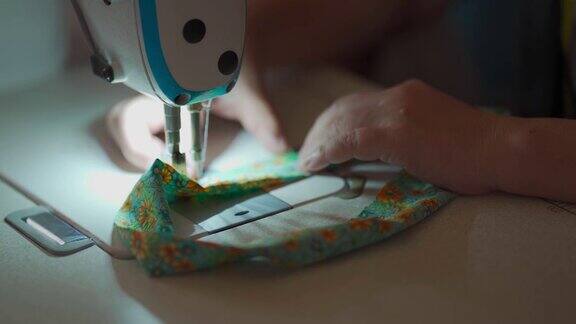 特写亚洲华人女裁缝的手工缝纫过程在缝纫机上缝纫