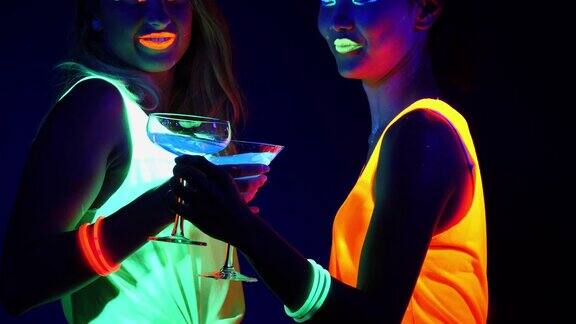 迷人的视频性感的网络raver女人拍摄在荧光衣服下的紫外线黑光两个性感的网络发光raver女人拍摄在紫外线黑光下荧光衣服派对概念