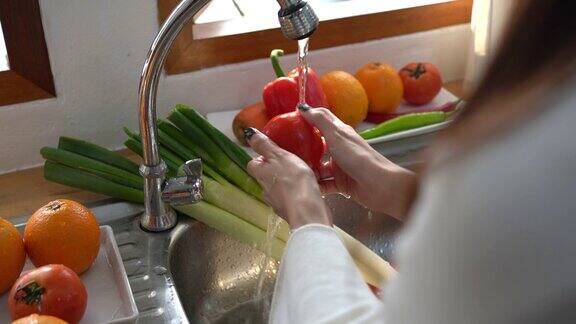 妇女在厨房清洗水果或蔬菜