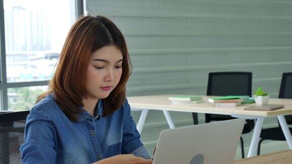妇女在家工作的笔记本电脑在线会议在家庭办公室亚洲女企业家用笔记本电脑坐在沙发上科技新常态的生活方式快乐的女人打字键盘笔记本电脑