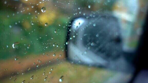 时间流逝水滴在窗户玻璃侧镜汽车背景在下雨