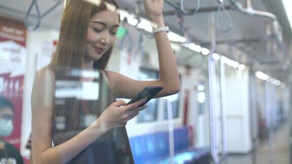 亚洲女性在地铁里使用手机