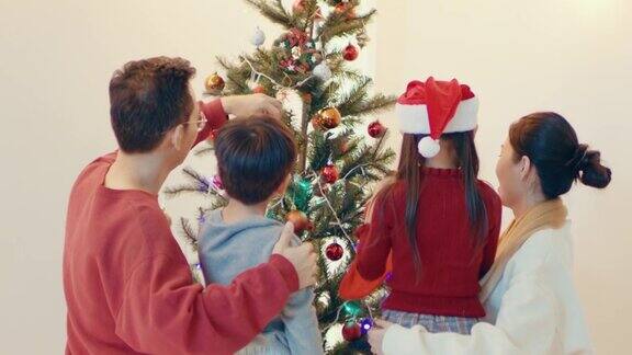 欢乐的家庭在装饰圣诞树的时候玩得很开心