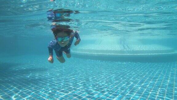 孩子享受暑假快乐的男孩在阳光明媚的日子跳进游泳池4K动态场景