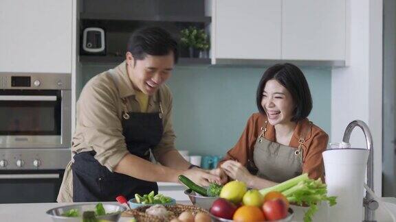 快乐的亚洲华人夫妇在厨房切菜
