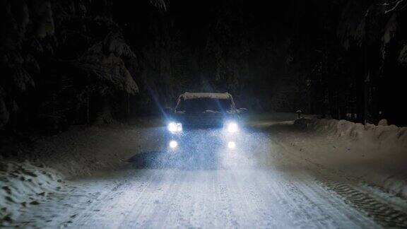 在下雪的夜晚汽车在下雪的路上行驶
