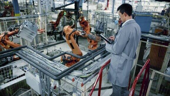 LD男亚洲工程师在工厂检查机器人的工作流程
