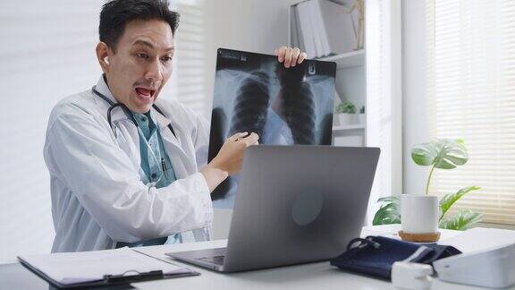 成熟的亚洲男性医生使用笔记本电脑视频通话的医疗结果在咨询患者在健康诊所
