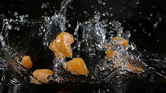 小柑橘网纹柑橘水果落在水对黑色背景慢镜头4K
