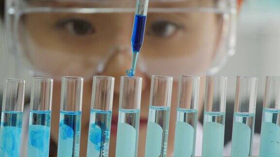 一个科学家用移液管分析有色液体从试管中提取DNA和分子