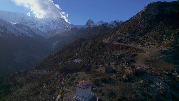 空中飞行在高海拔地区被废弃的村庄建筑的佛塔上喜马拉雅山山脉和观光安纳普尔纳环行