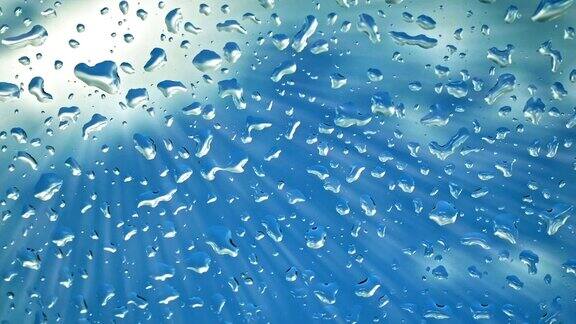 以蓝天为背景的雨点落在挡风玻璃上