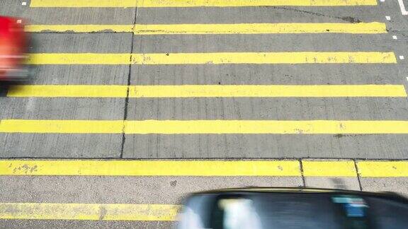 在香港孟角区一群无法辨认的行人和汽车在黄色斑马线上行走