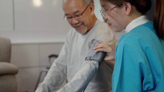 亚洲护理医生用血压计检查老年病人护士来访和照顾病人老人体检老人老人在客厅医疗保险