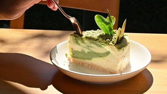 有人在吃之前用勺子切一片抹绿蛋糕
