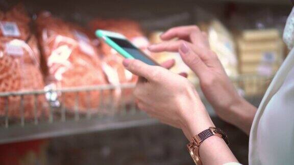 女人在超市使用智能手机特写