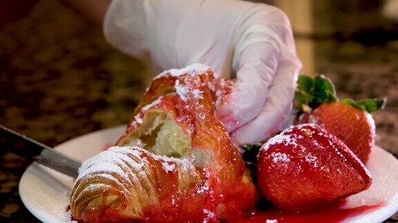 削减厨师美味新鲜的羊角面包草莓糖浆来弄脏手我想用舌头舔盘子里新鲜的草莓松饼的结构