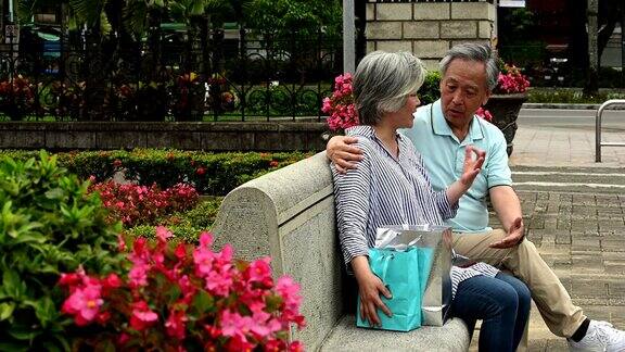 一对老年夫妇在公园长椅上放松聊天