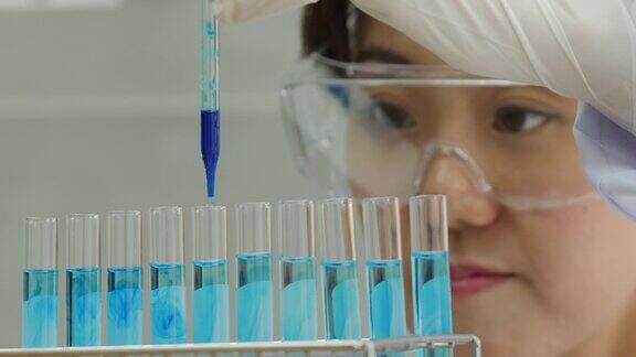 一个科学家用移液管分析有色液体从试管中提取DNA和分子