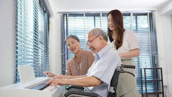 亚洲老年妇女和女儿带着年长男子在家里弹钢琴美丽的老祖母和爷爷感到快乐和放松而花空闲时间在家里学习音乐教室
